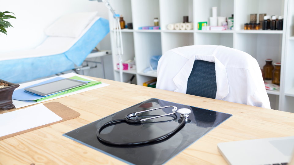 empty doctor's office with a stethoscope on the desk